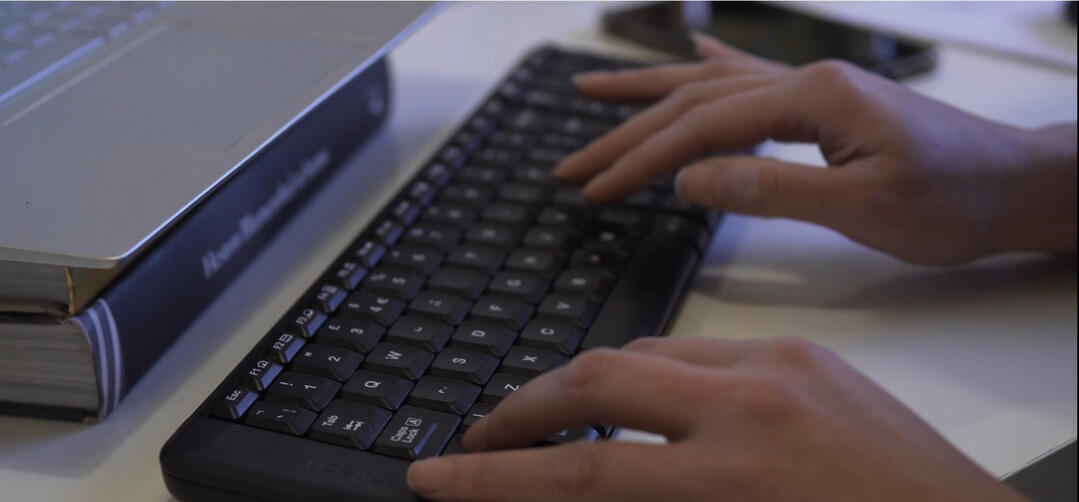 Amelia Epton focused on grant writing, typing on her keyboard to secure funding for charities.