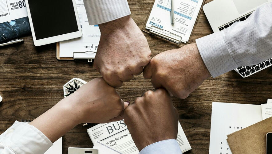 Group of hands fist pumping, symbolising collaboration and successful fundraising strategies.